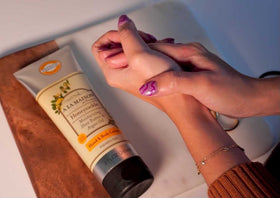 Hands applying A LA MAISON Honeysuckle lotion on skin