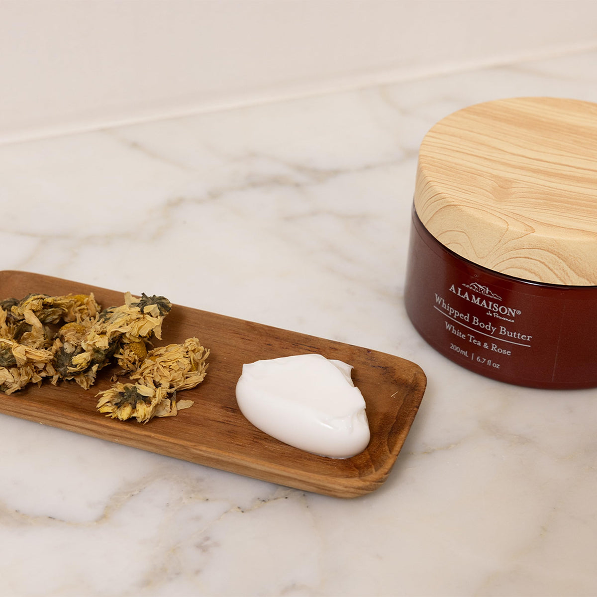 A LA MAISON hand application shows creamy texture sinking in.