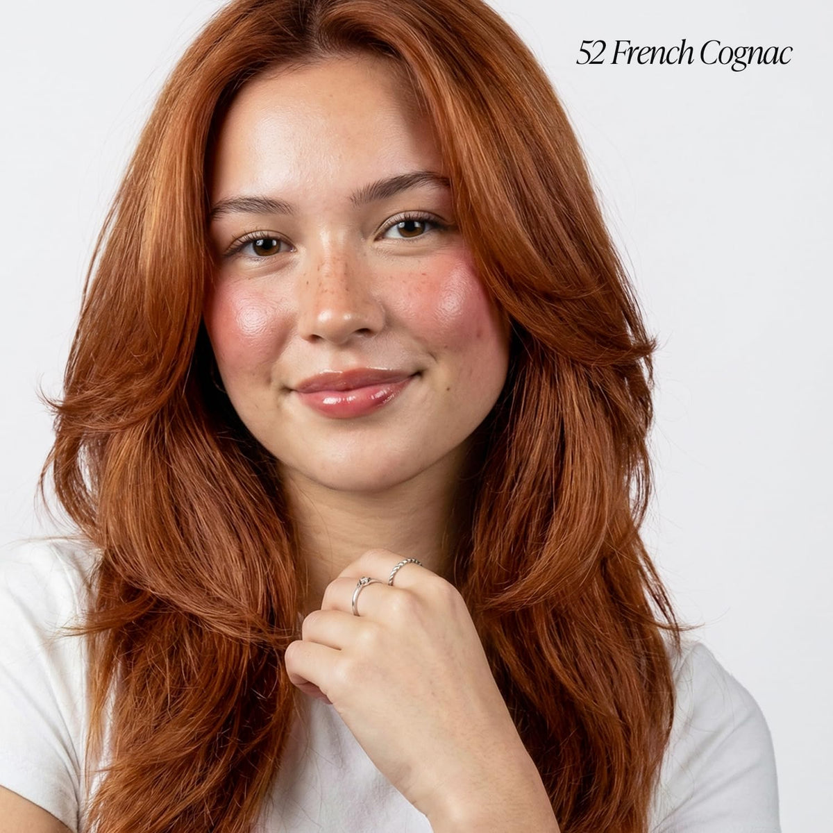 Applying Adore 052 French Cognac on hair for smooth, uniform coverage.