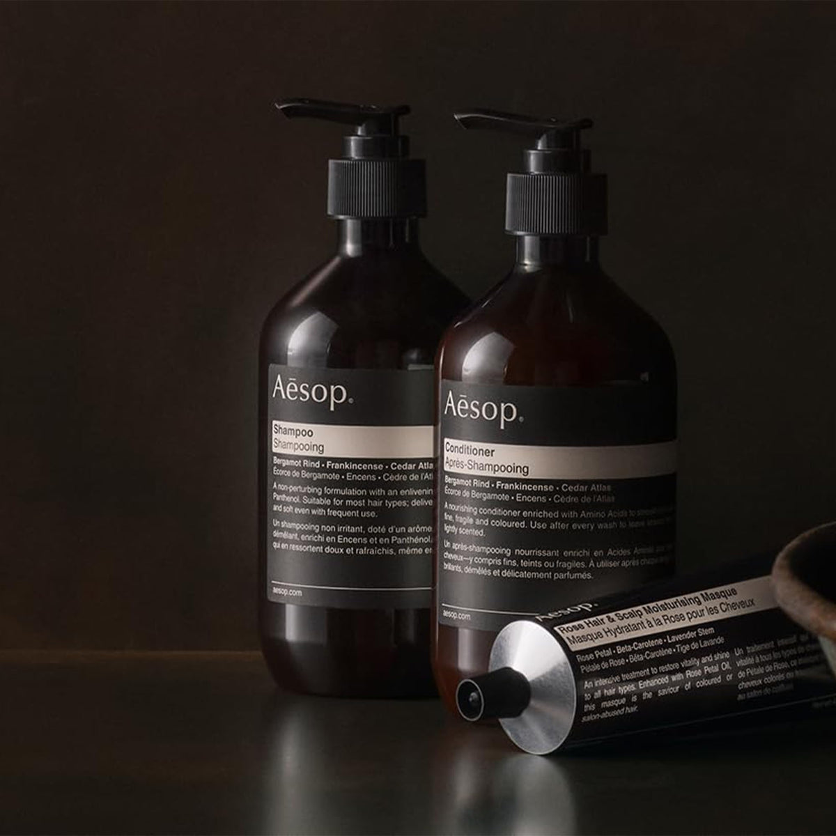 Aesop conditioner being applied to hair for even distribution.