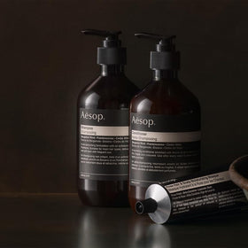 Aesop conditioner being applied to hair for even distribution.