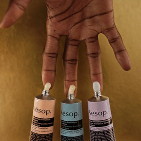 Aesop hand balm travel-size trio arranged on a tray for on-the-go hydration.