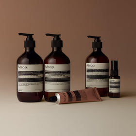 Applying Aesop balm on hands to nourish dry skin around cuticles
