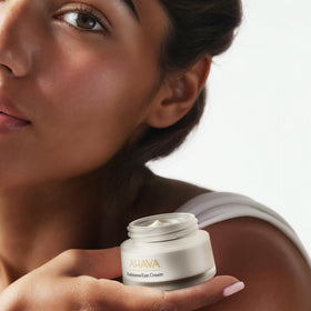 AHAVA eye-area application scene with ring finger patting technique for gentle absorption.