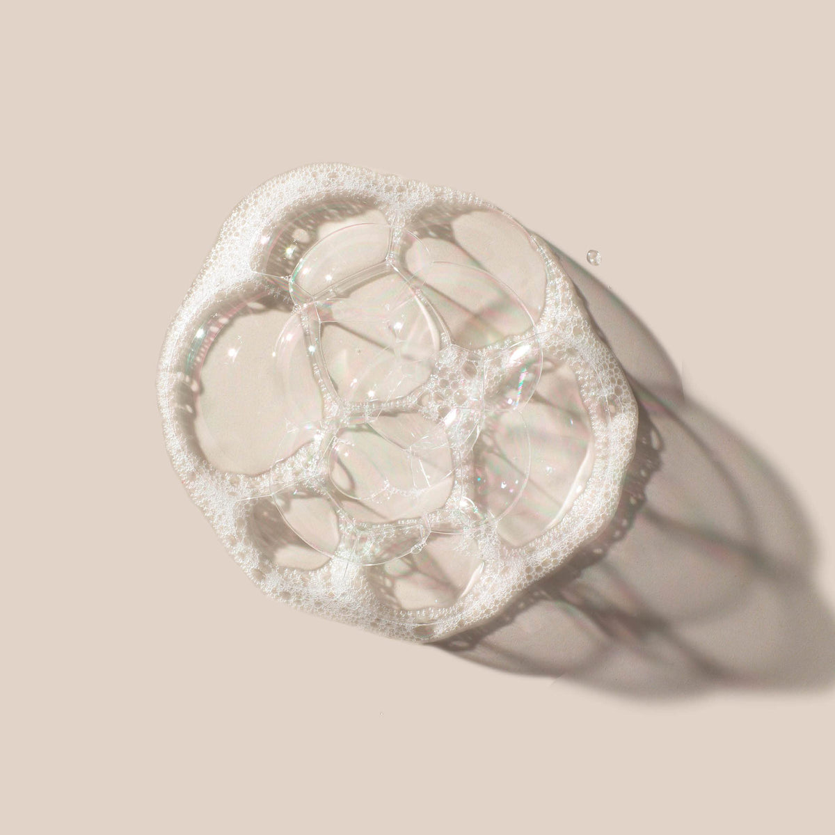 AHAVA face and body cleansing bar rests on a washbasin for versatile use.