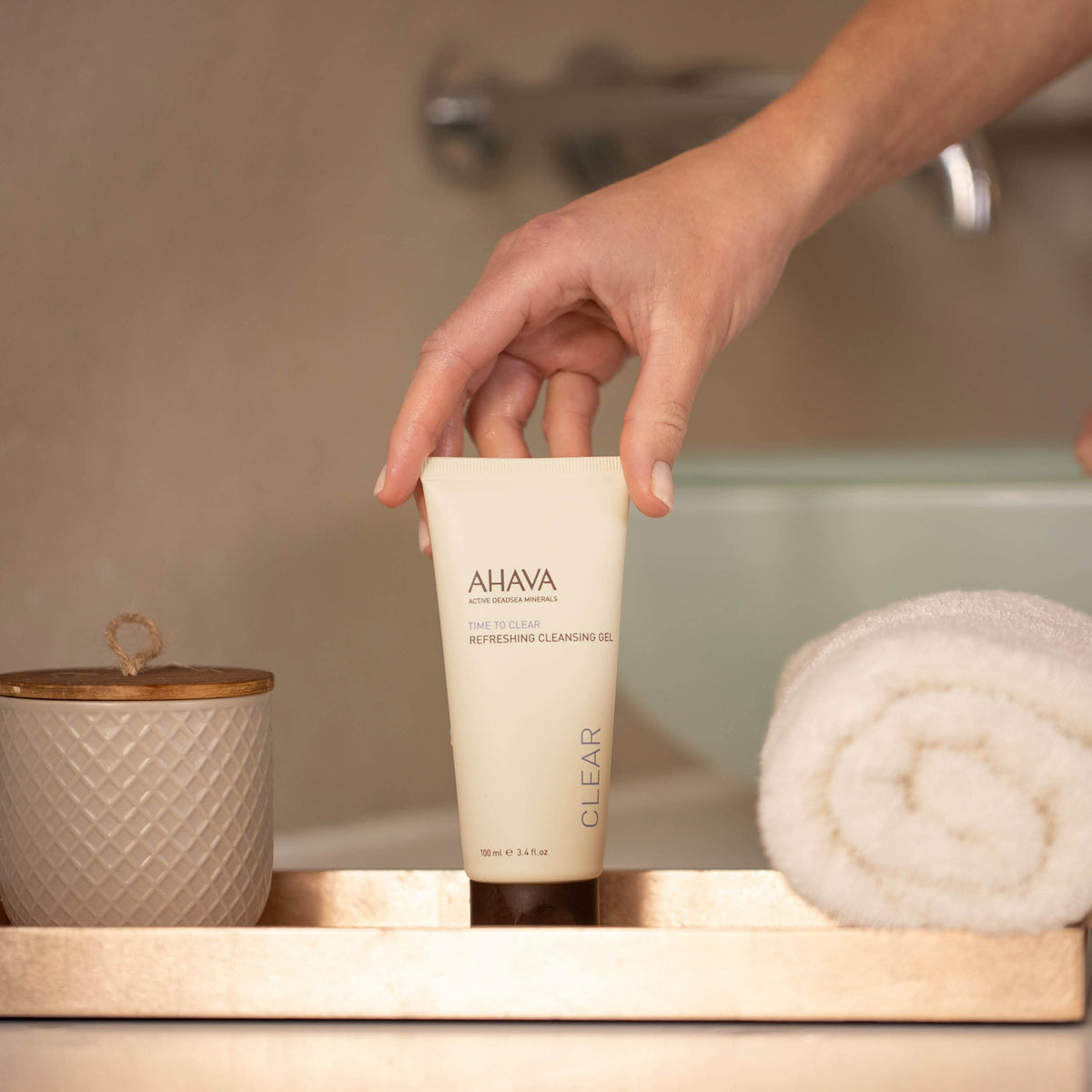 AHAVA cleansing gel in action removing makeup gently from cheeks.