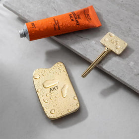 AKT applicator gliding over underarms for even balm distribution.