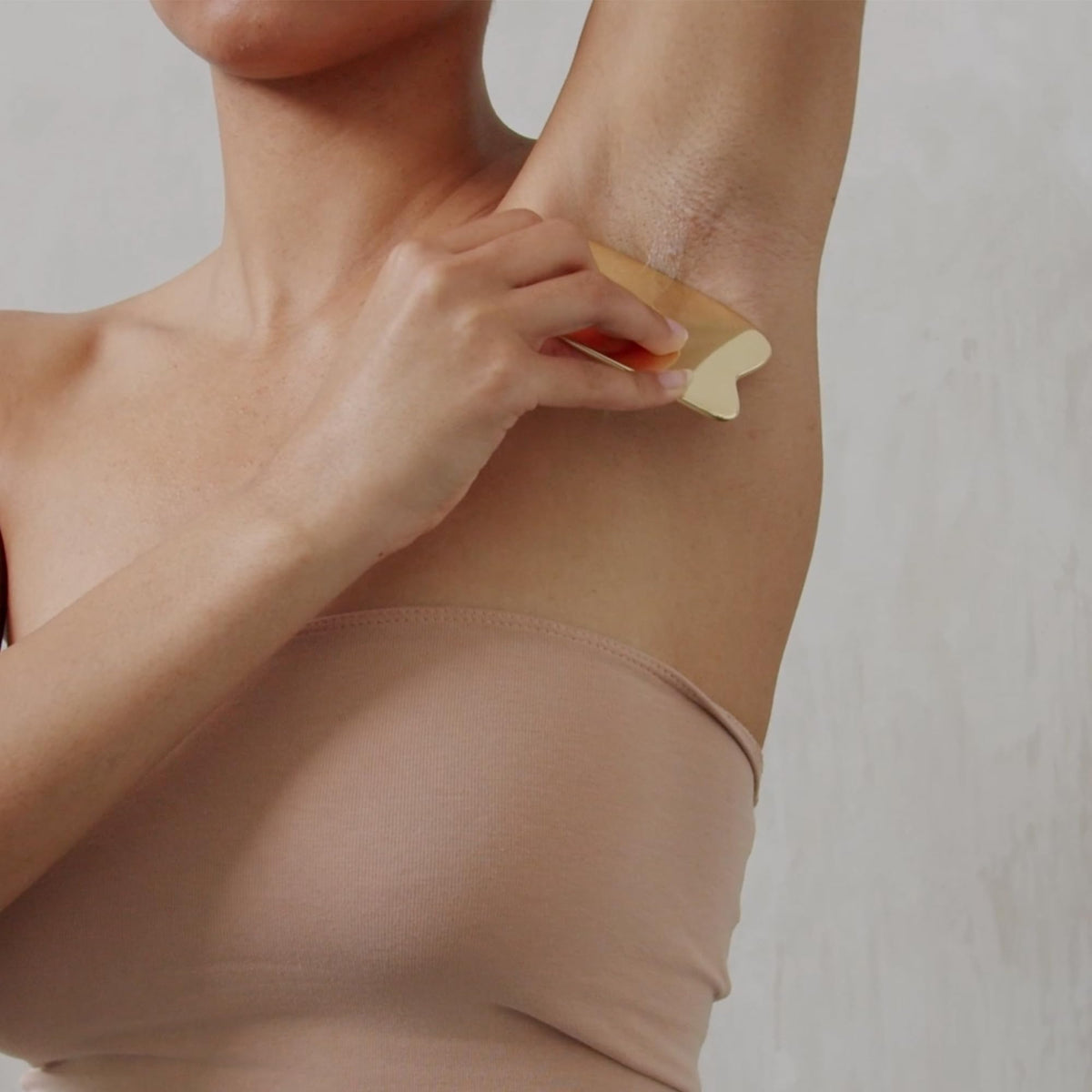 AKT deodorant balm applicator in hand during self-care routine.