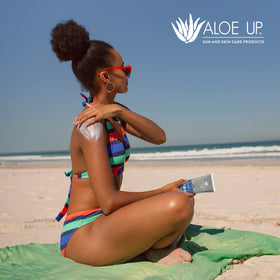 Front-view Aloe Up Sport Sunscreen with outdoor sport backdrop.