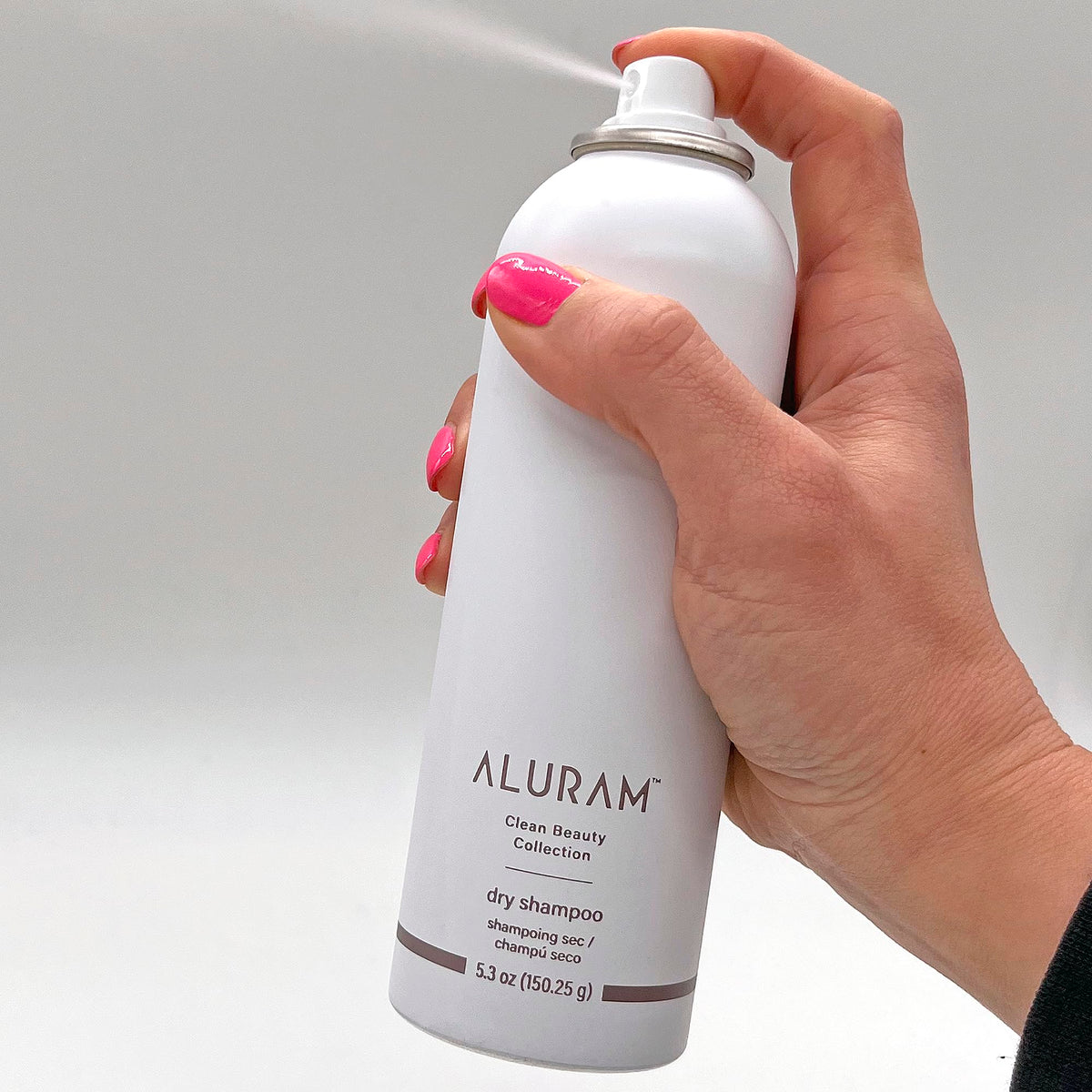 Close-up of ALURAM Dry Shampoo being applied for quick touch-ups.
