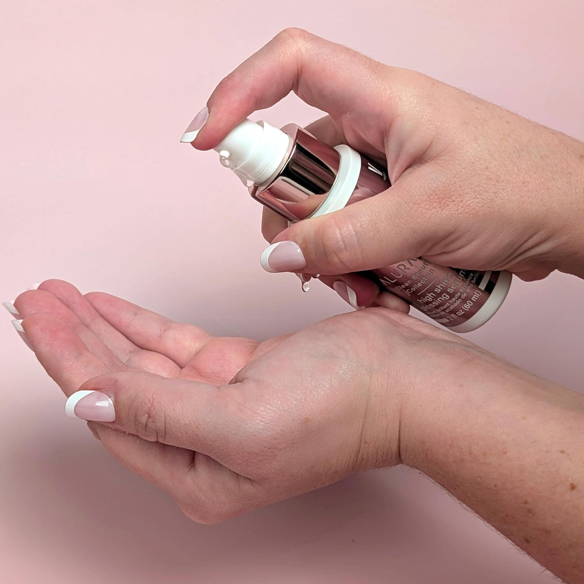 Hands applying ALURAM High Shine Glossing Serum for smooth, glossy strands