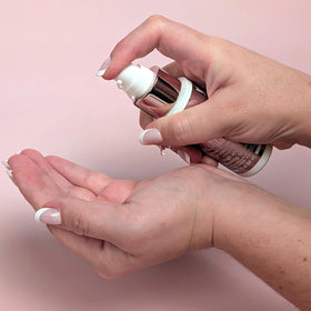 Hands applying ALURAM High Shine Glossing Serum for smooth, glossy strands