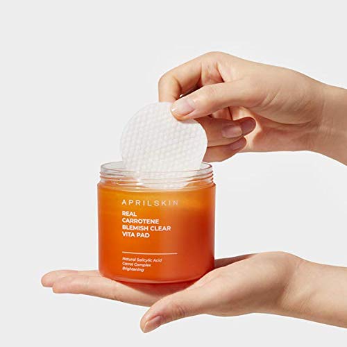Applying APRILSKIN Carrotene Clarifying Pads on cheek during routine.