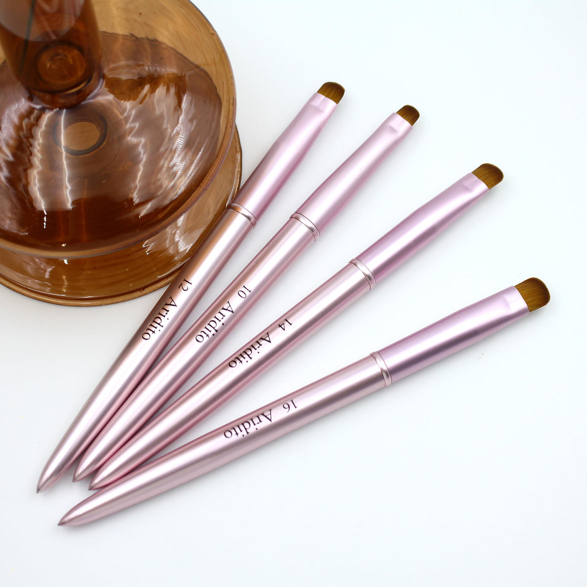 Aridito pink metal nail cleanup brush close view highlighting compact size.