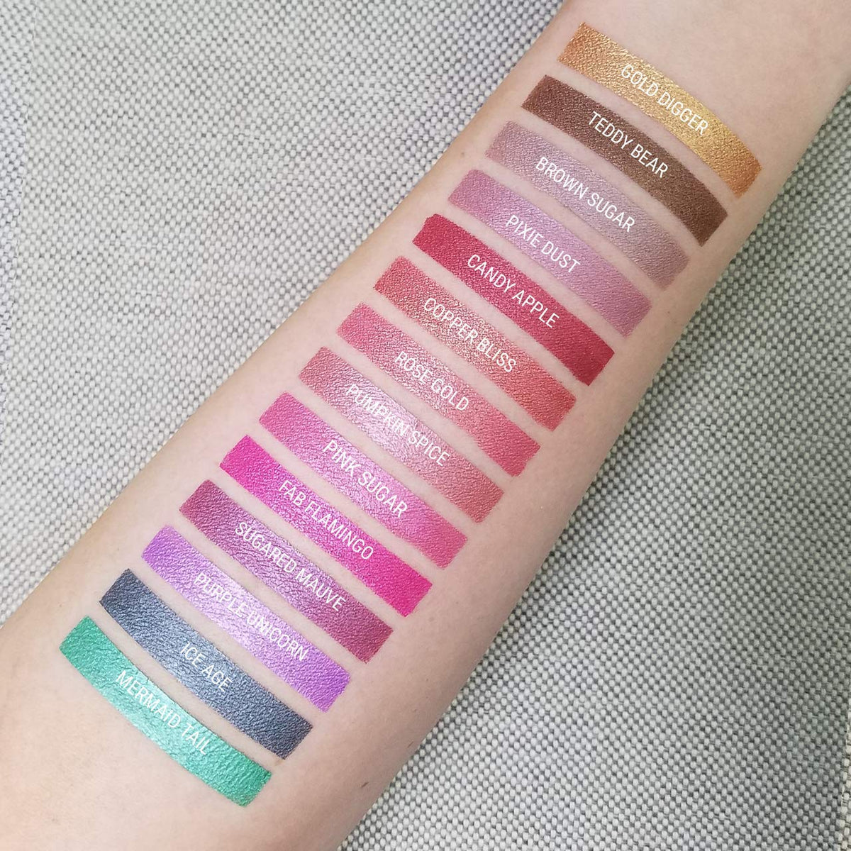 Aromi Fab Flamingo metallic swatch on skin demonstrates vibrant magenta shimmer.