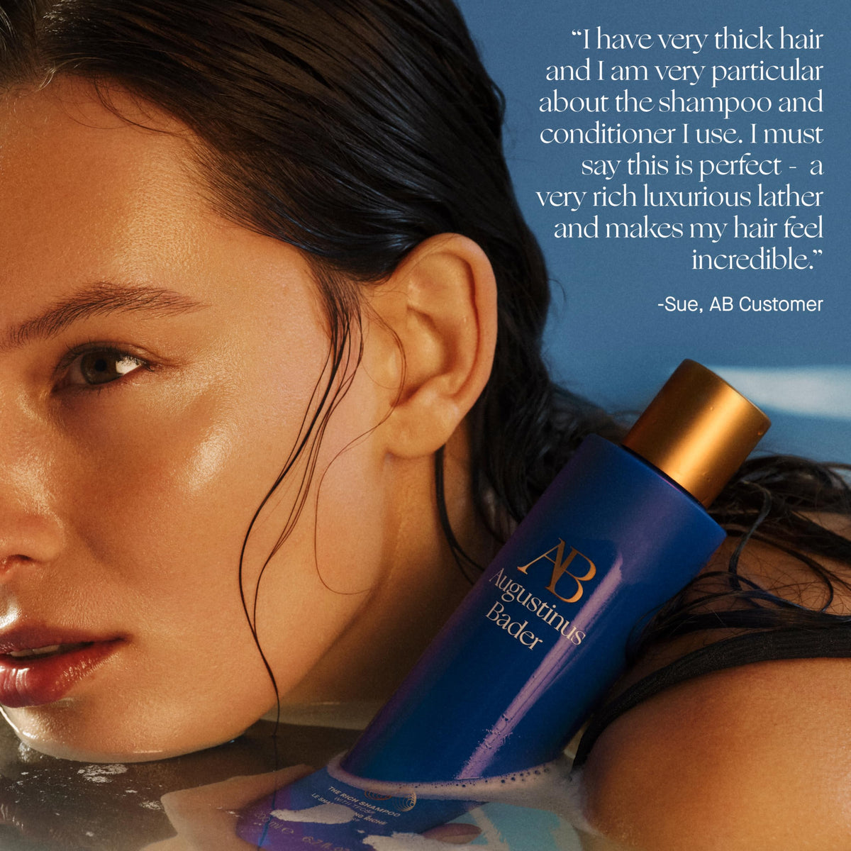 Hands applying Augustinus Bader The Rich Shampoo into wet hair.