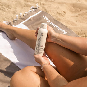 Australian Gold tinted sunscreen spray in action dispensing mist with no mess