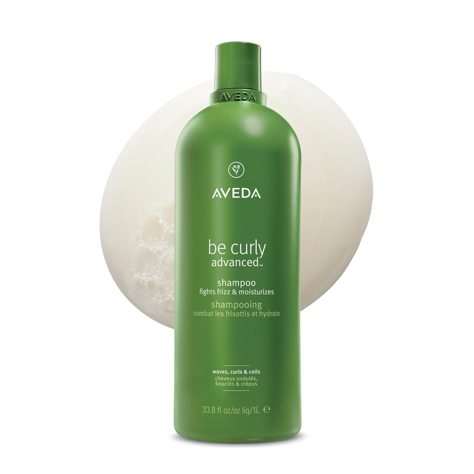 Aveda Be Curly Advanced Shampoo bottle pouring, gentle cleanse for curls