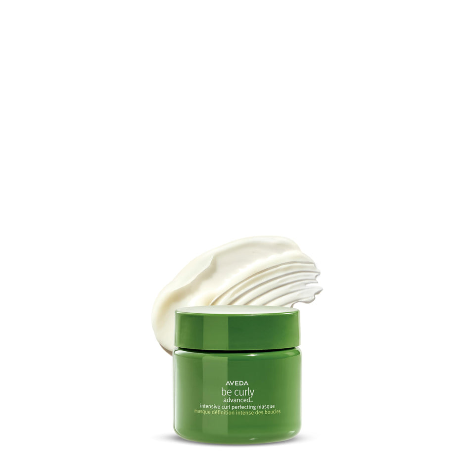Aveda Be Curly bottle pouring, demonstrating quick conditioning for curls.
