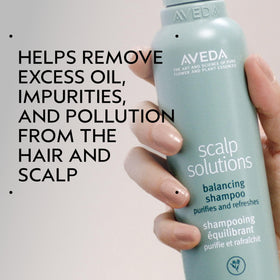 Aveda Scalp Solutions Balancing Shampoo being poured for a refreshing cleanse.