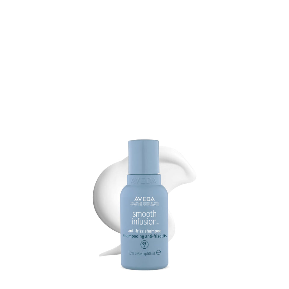 Aveda Smooth Infusion Anti-Frizz Shampoo bottle demonstrates frizz control during styling.