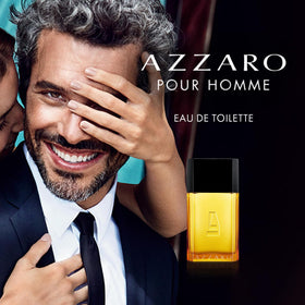 Azzaro Pour Homme bottle bathed in warm amber lighting.