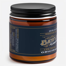 Hands applying Battle Born Original Pomade for easy styling and shaping.