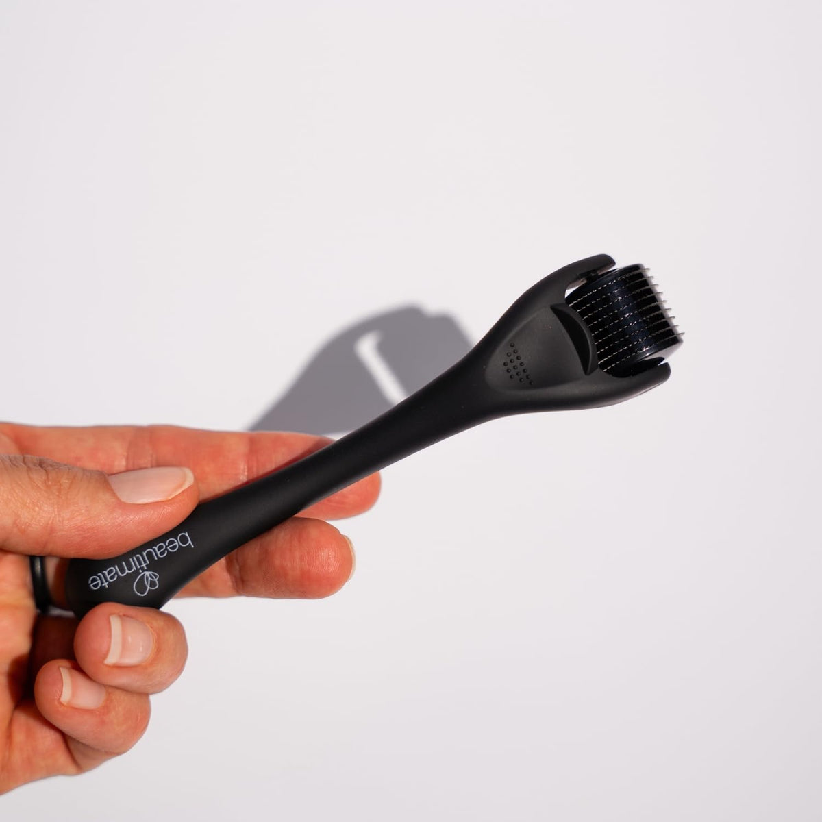 Hands rolling gently on skin with Beautimate tool.
