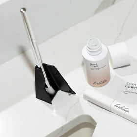 Borboleta Clean Swoop Brush curves to hug the lash line during cleansing.