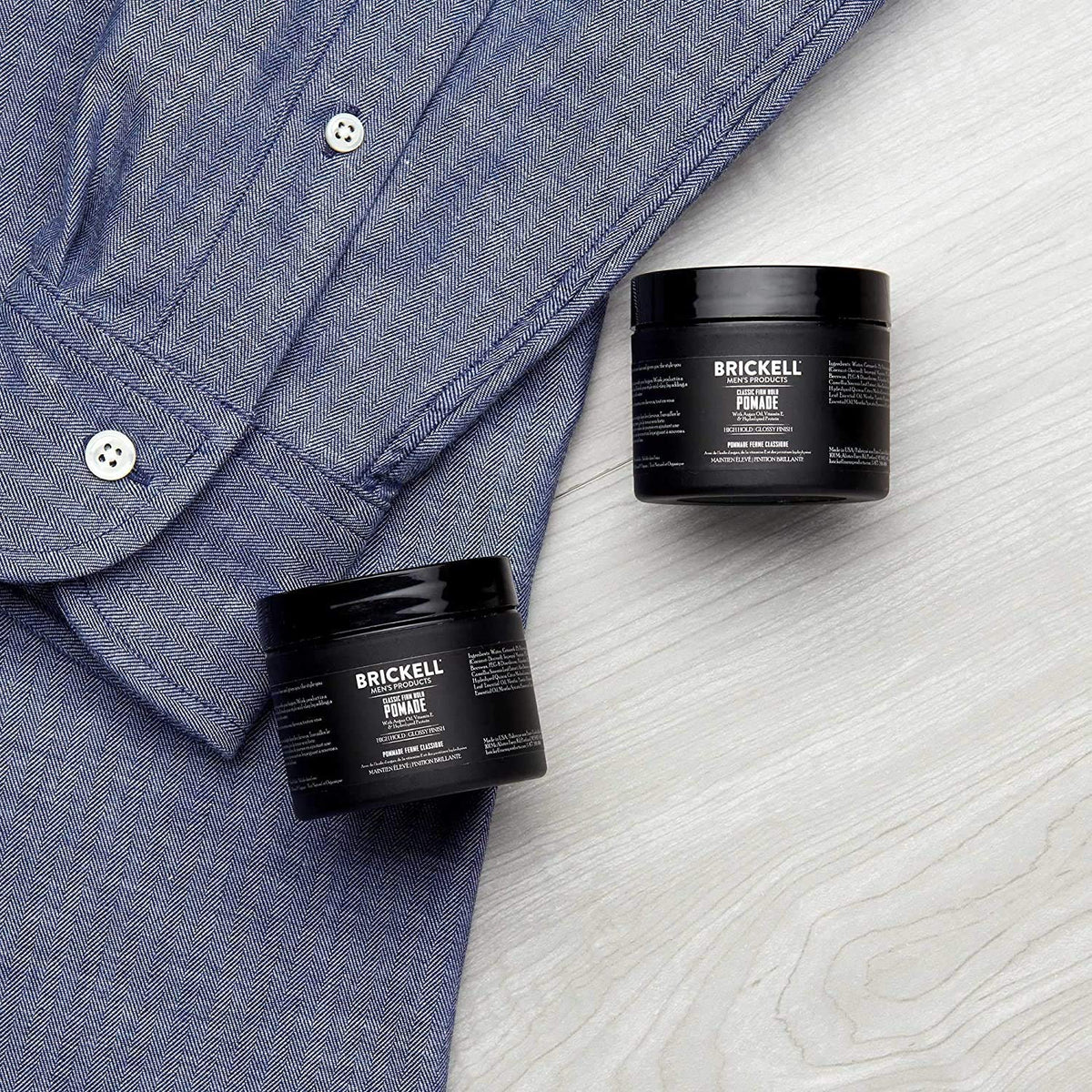 Brickell Men's pomade being applied by hands for slicked-back style with long-lasting hold