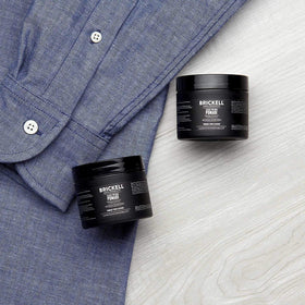 Brickell Men's pomade being applied by hands for slicked-back style with long-lasting hold