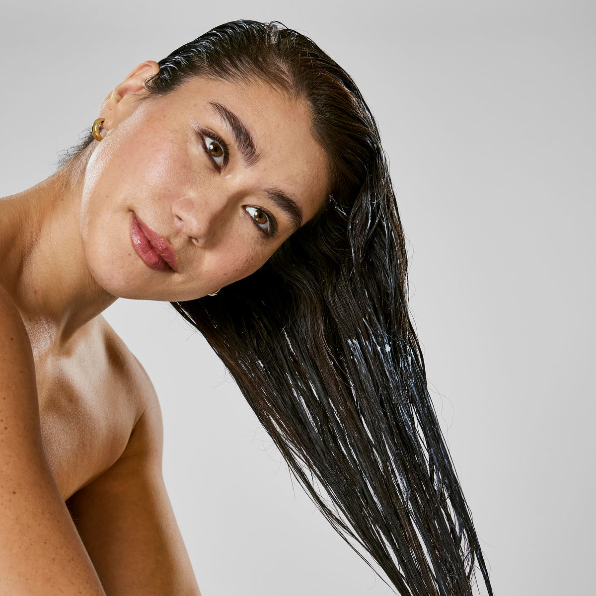 Bumble and bumble Hair Mask application on hair seals frizz protection.