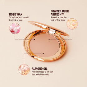 Charlotte Tilbury powder brush application across the center of the face.