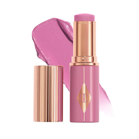 Charlotte Tilbury Unreal Healthy Glow Blush Stick on cheek for juicy-sheen radiance.