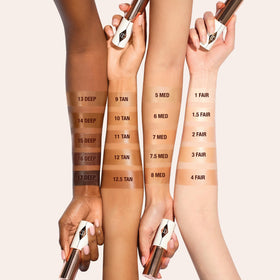 Charlotte Tilbury Unreal Skin Tint packaging on vanity with premium look.