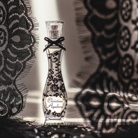 Amber and vanilla note artwork on Christina Aguilera Signature bottle suggesting warm versatility.