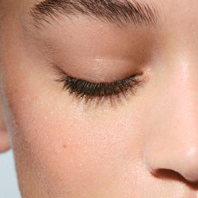 Clarins Micellar Water on a cotton pad for makeup removal and skin refreshment.