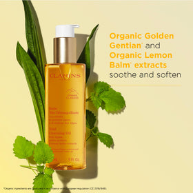 Applying Clarins Total Cleansing Oil to the face for gentle cleansing.