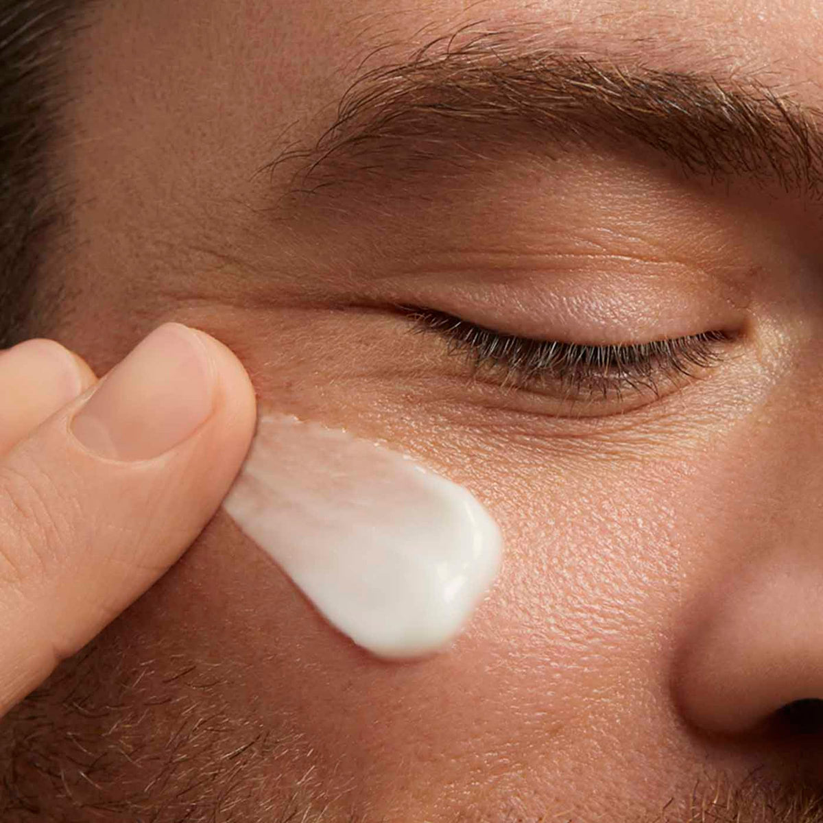 ClarinsMen cream being applied to cheek for smooth, even coverage