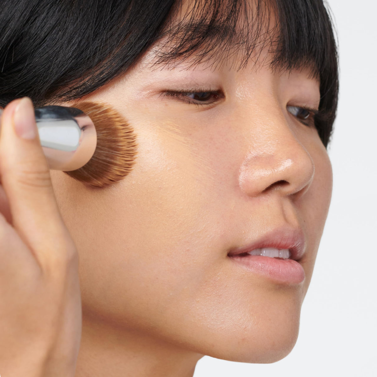 Clinique buffing brush used from the center of the face outward for a seamless finish.