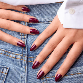 Rio Red strips on nails reveal a glittery burgundy finish.