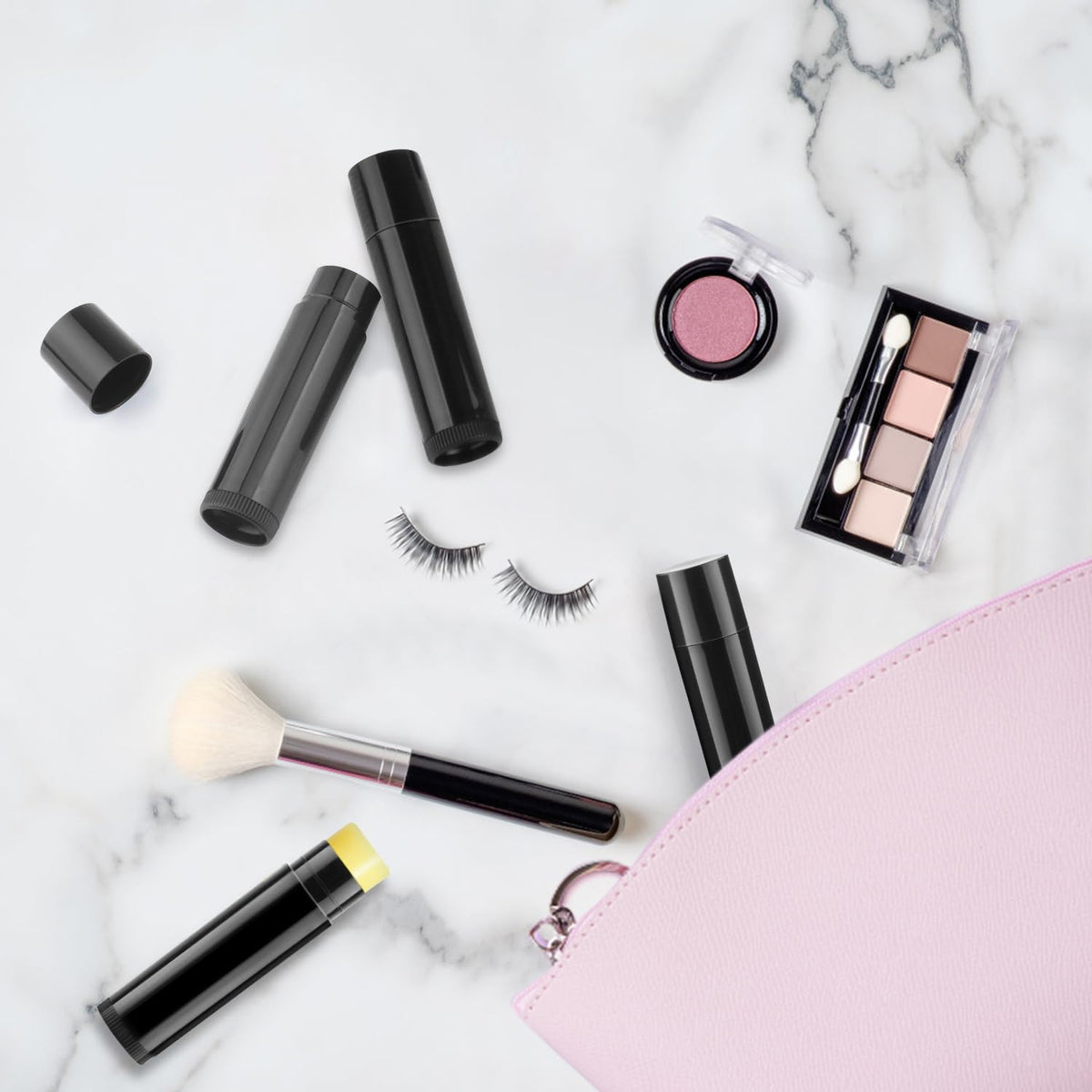 Cositina black lip balm tubes in hand illustrating portable use.