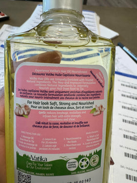 Dabur Vatika Naturals Enriched Hair Oil closeup shows garlic essence boosting vitality.