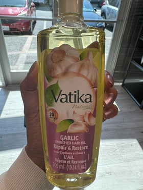 Dabur Vatika Naturals Enriched Hair Oil being poured for easy daily application.
