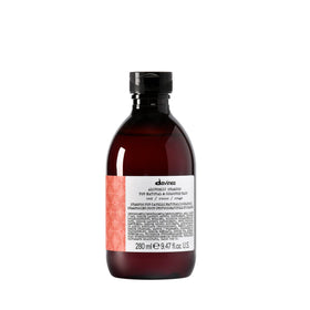 Davines Alchemic Shampoo Red bottle demonstrates color enhancement for warm red tones.