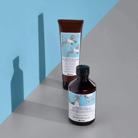 Davines in-shower scene with rich lather cleansing the hair.