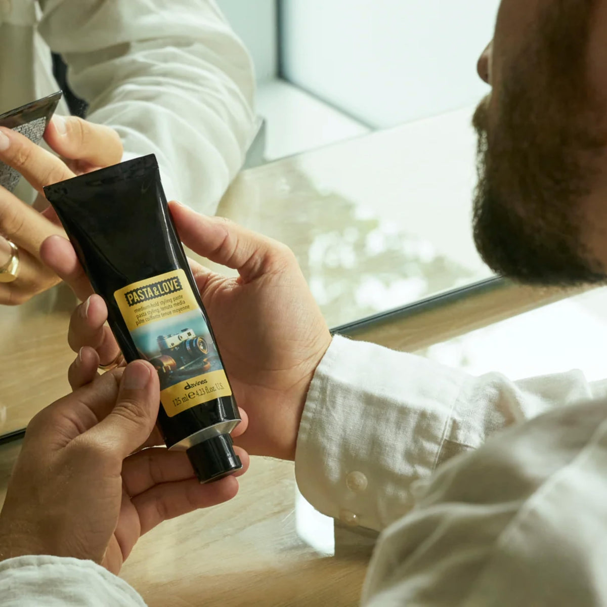 Davines Pasta and Love paste on hands dispersal visual for even coverage.