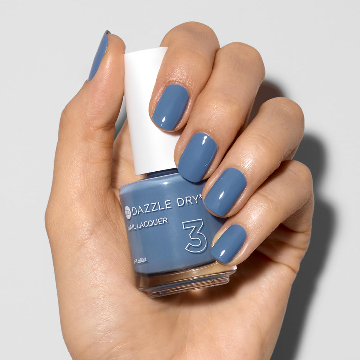 Close up of Dazzle Dry Varsity Blues nails during manicure