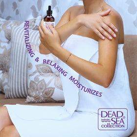 Applying Dead Sea Collection body oil to damp skin after shower