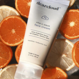 Dearcloud Vita-C Aqua bottle on counter conveys premium skincare in daily routine.